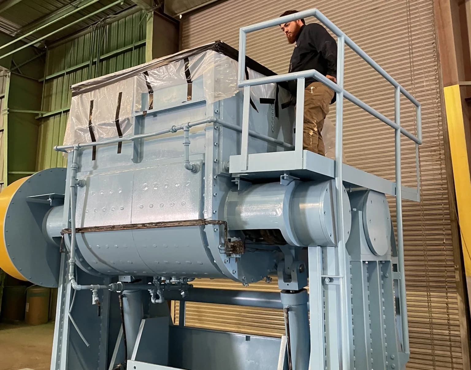 A large finished blue-gray double-arm Sigma mixer with an operator catwalk at Gear Force Machine.