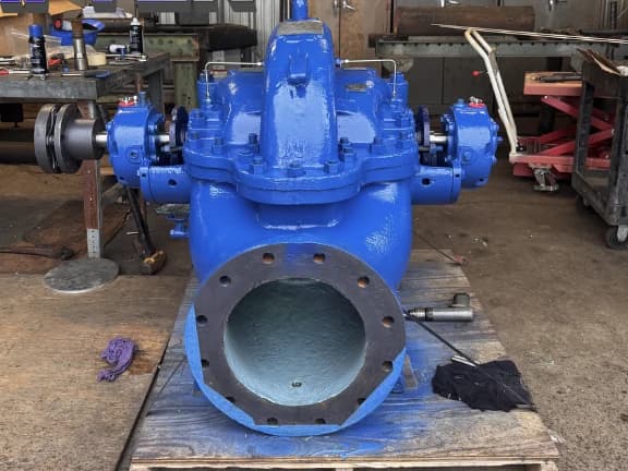 A rebuilt split-case centrifugal pump repainted in fresh blue, staged on a pallet in the Gear Force Machine shop.