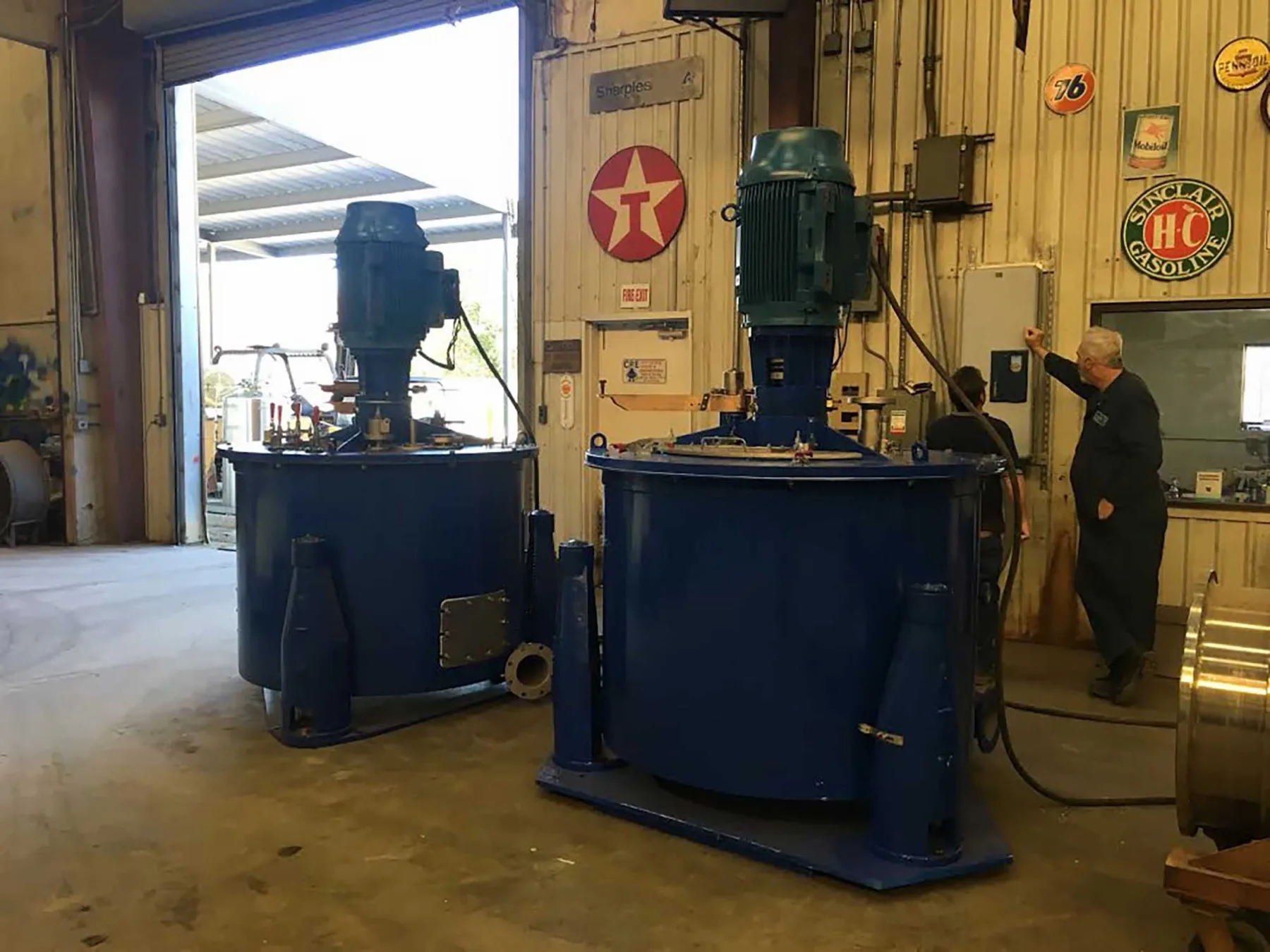 Two blue top-drive basket centrifuges in the Gear Force Machine shop, staged for rebuild for a mining operation.