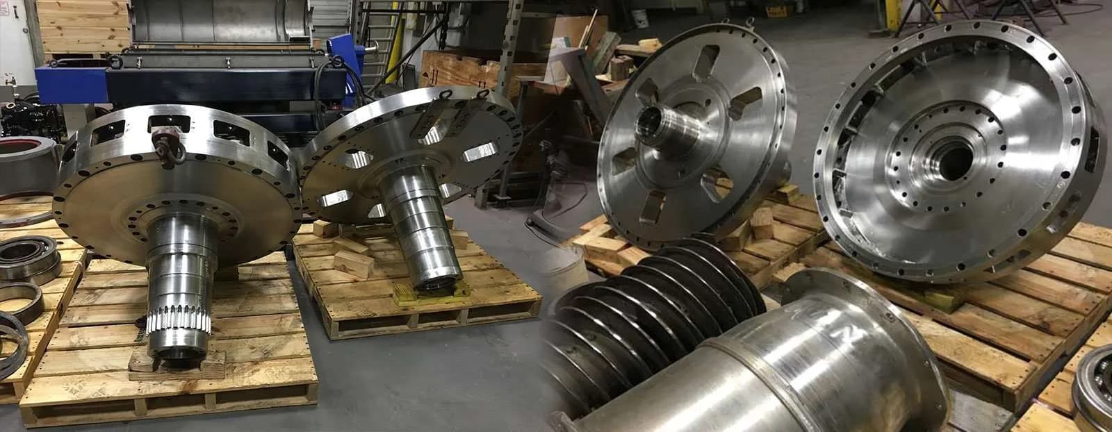Rebuilt centrifuge scroll conveyors and bowl heads laid out on pallets at the Gear Force Machine shop.