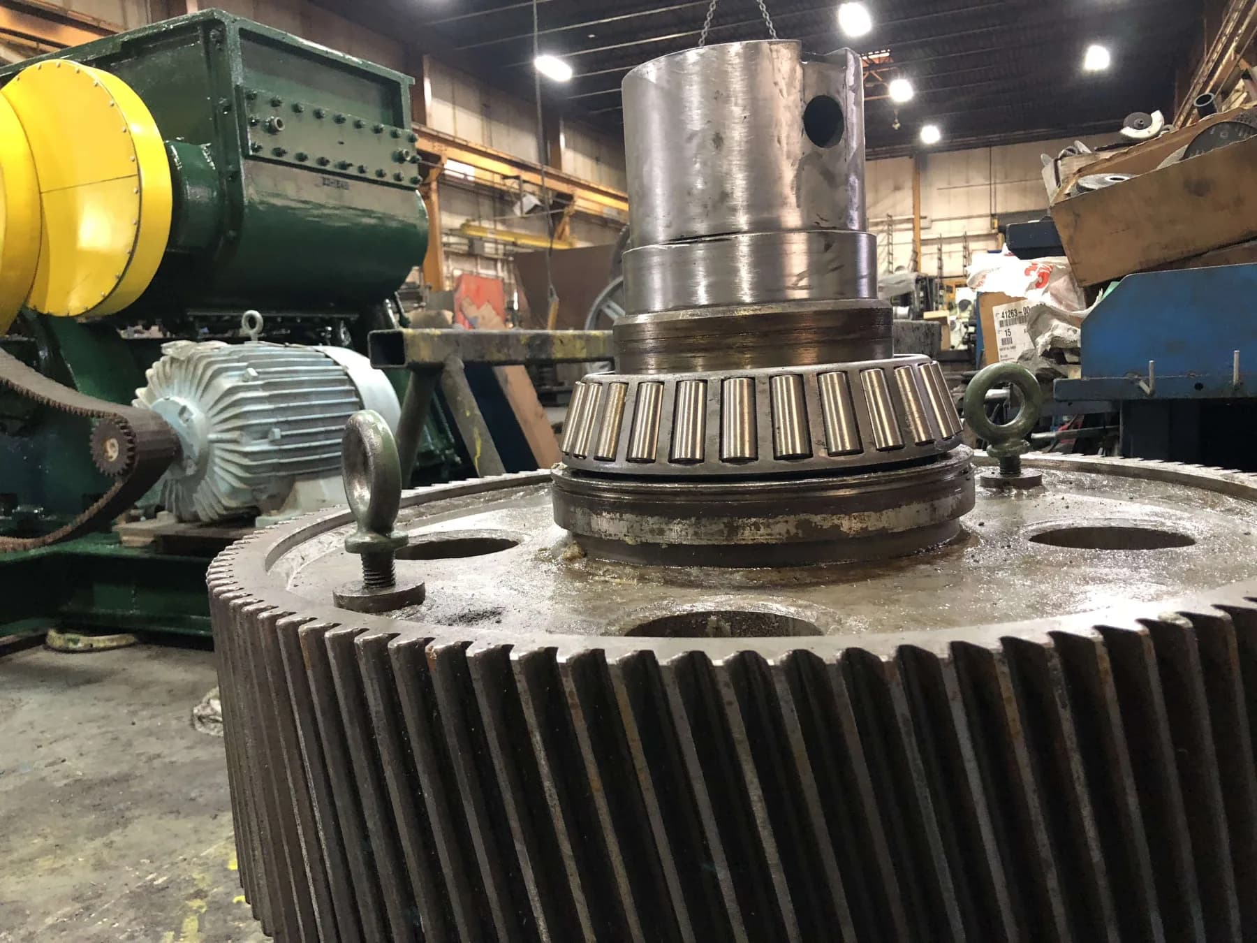 A large helical mill gear with a tapered roller bearing and shaft being assembled on the Gear Force Machine shop floor.