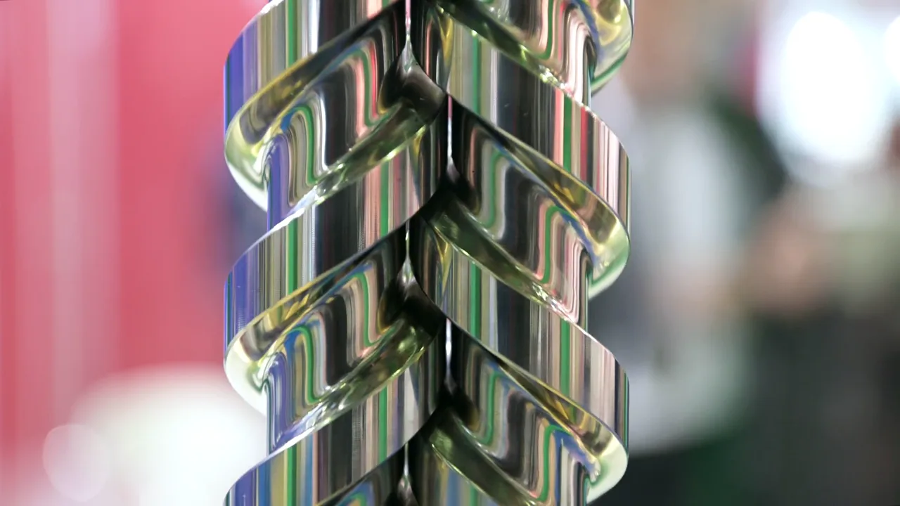 Close-up of rotating twin-screw extruder augers — representative of the industrial extruder equipment Gear Force Machine services.