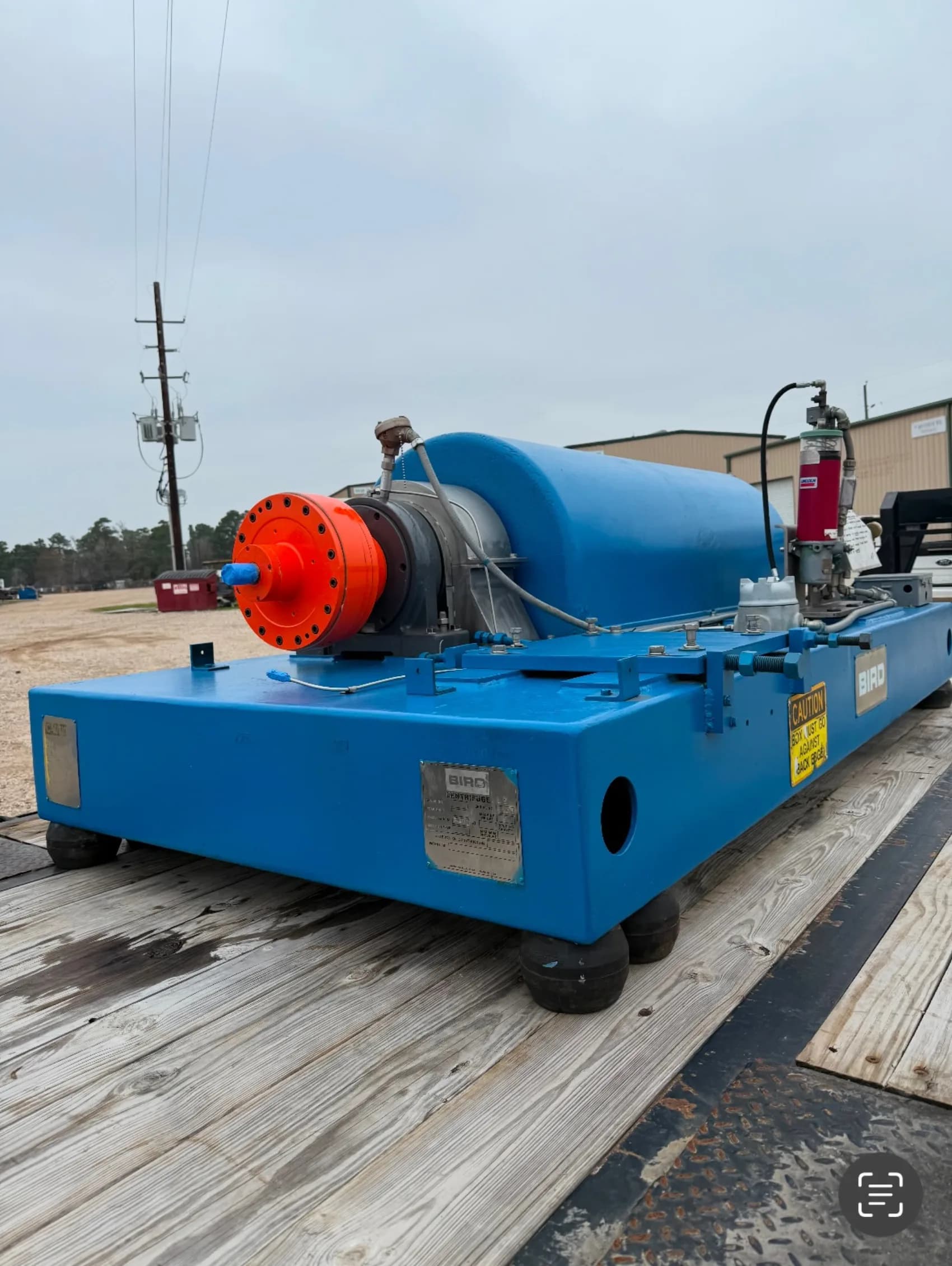 A rebuilt Bird decanter centrifuge in fresh blue paint with an orange backdrive gearbox at Gear Force Machine.