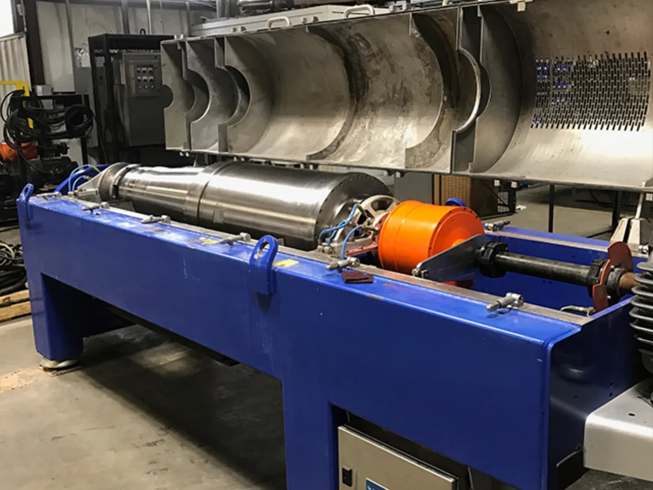 A blue decanter centrifuge on its stand in the Gear Force Machine shop.