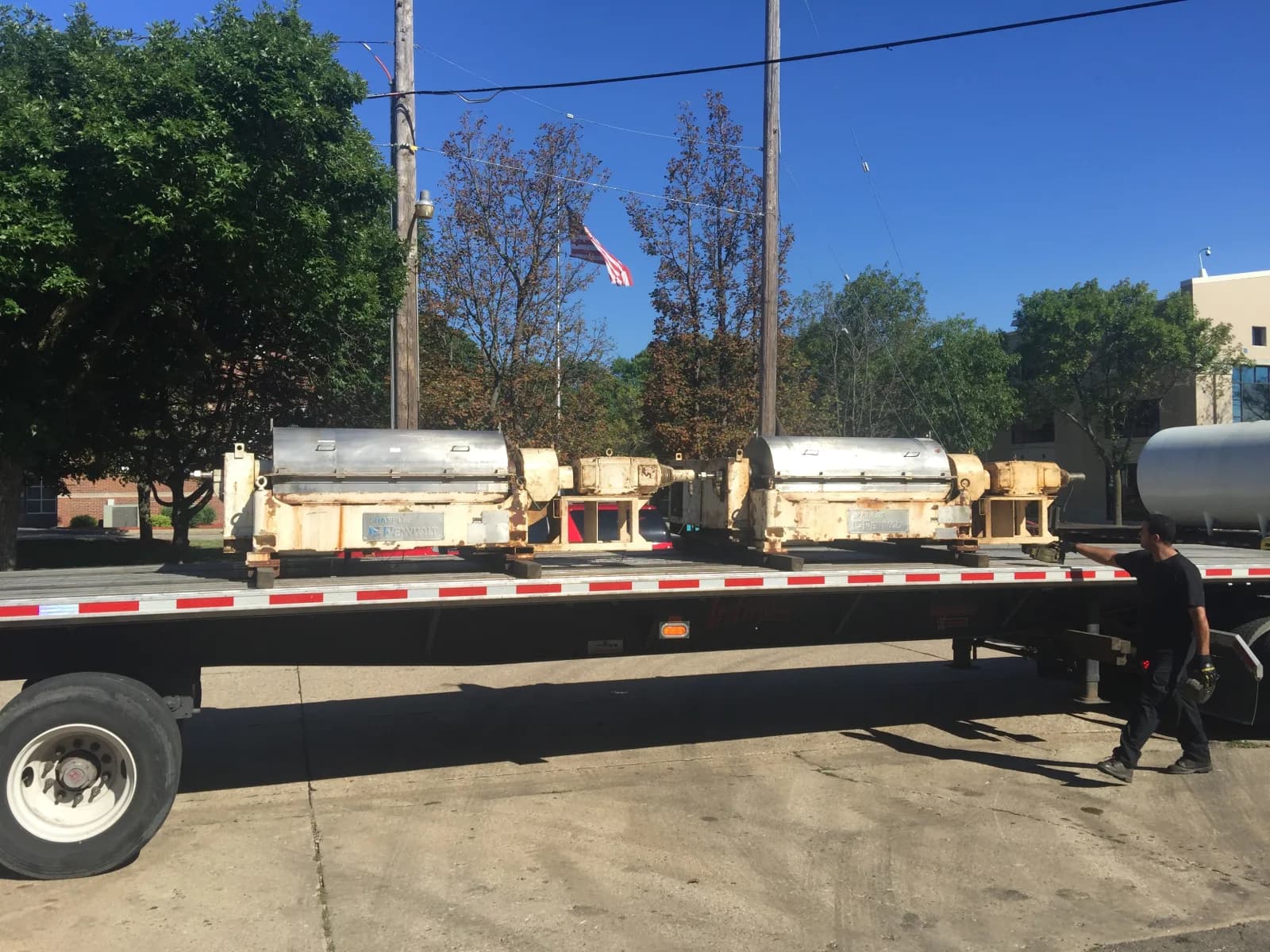 Two industrial decanter centrifuges loaded on a flatbed at Gear Force Machine, inbound for rebuild for a food and beverage plant.