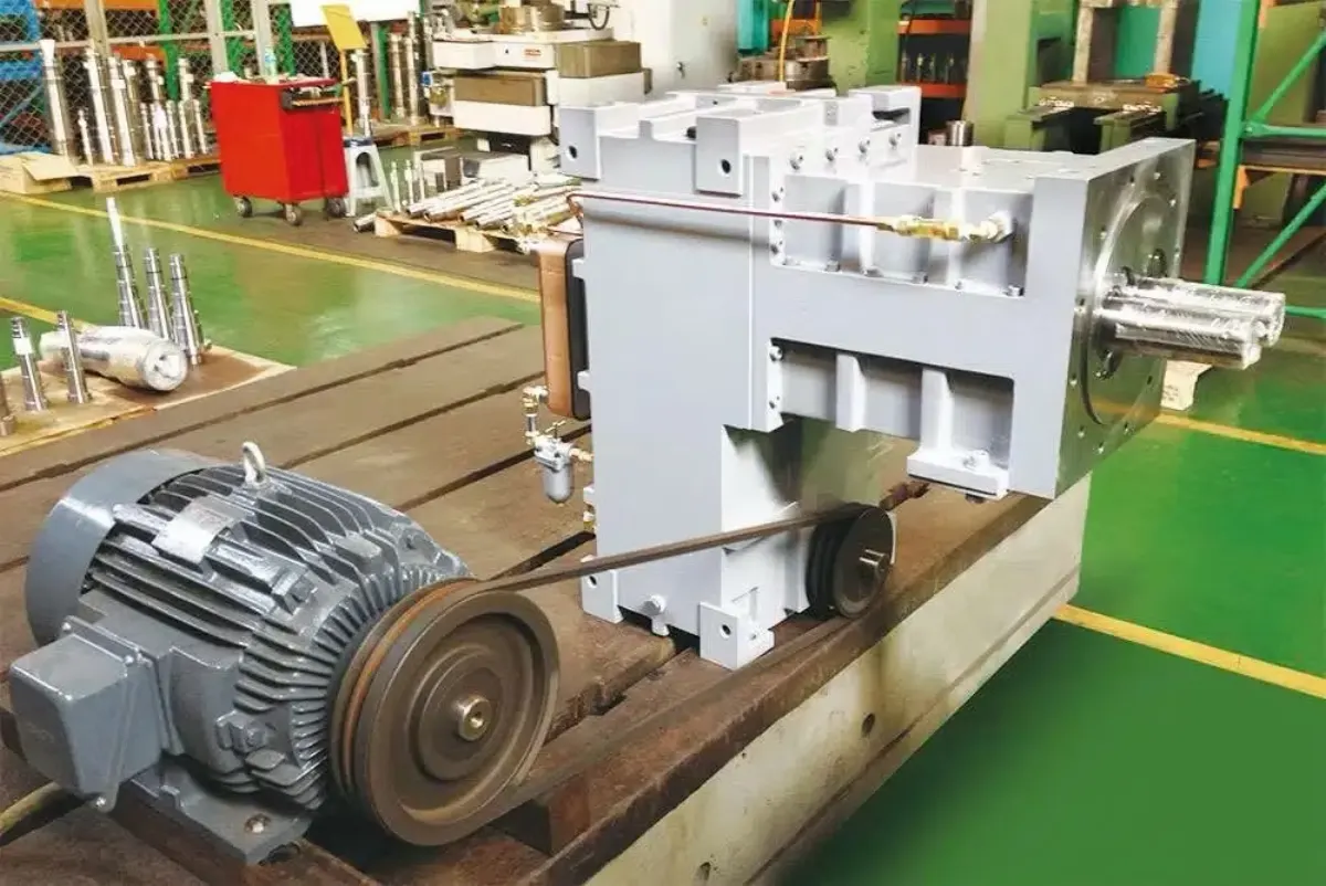 A rebuilt extruder drive assembly with mounted electric motor and V-belt pulley, staged for test-run.