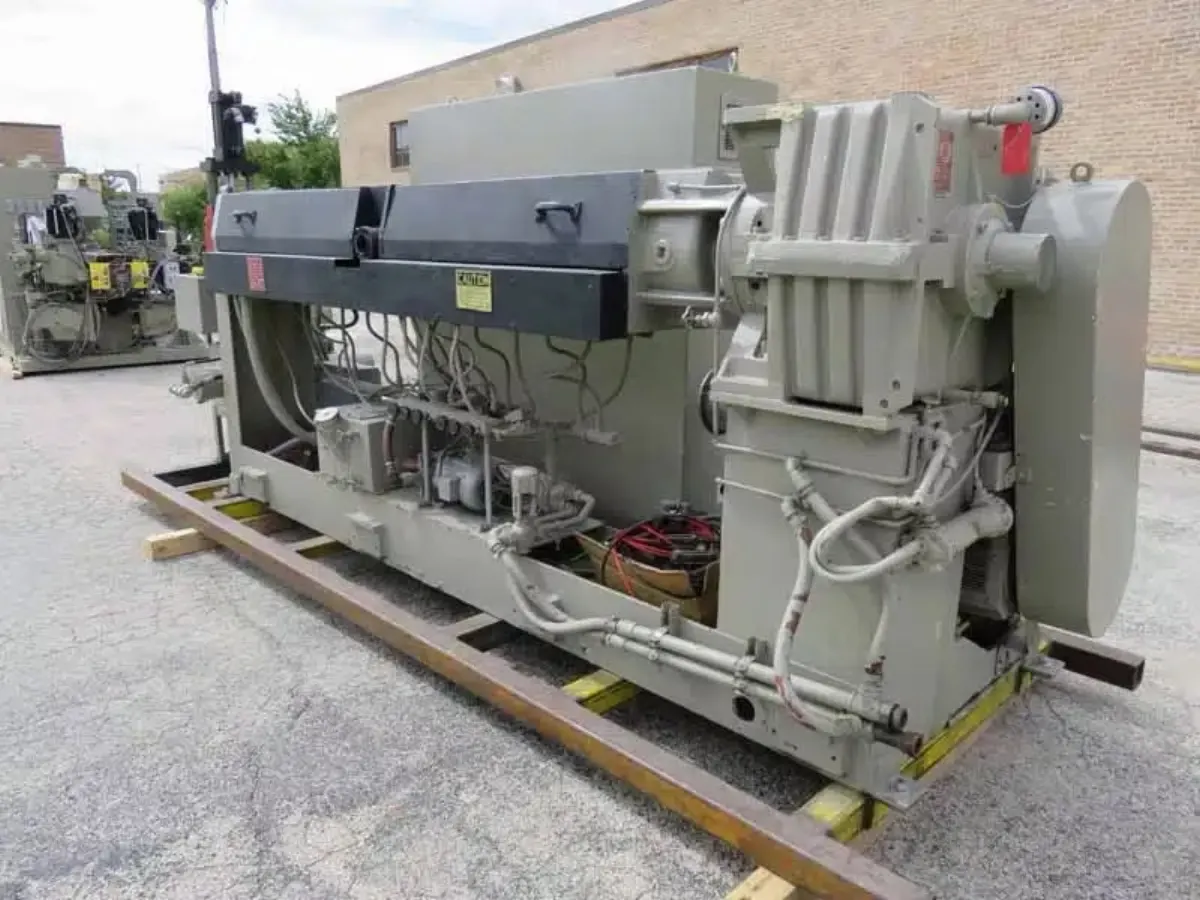 A grey industrial extruder in its production environment before teardown and rebuild.