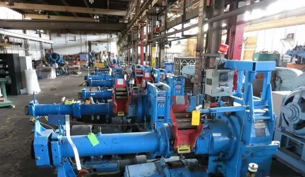 A row of blue industrial extruders lined up on the Gear Force Machine shop floor during teardown and inspection.