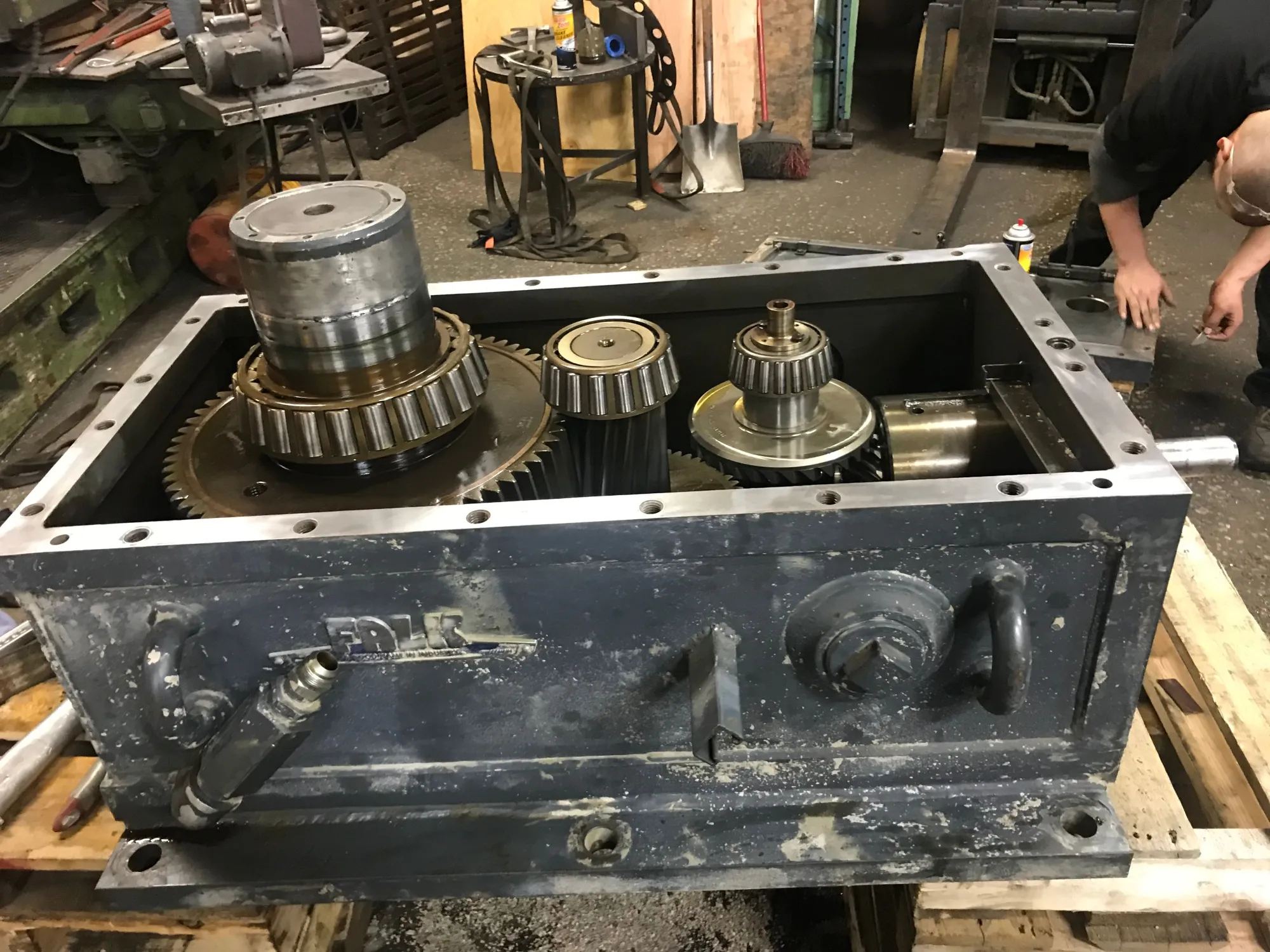 An open industrial gearbox with the full gear train exposed during inspection at Gear Force Machine.
