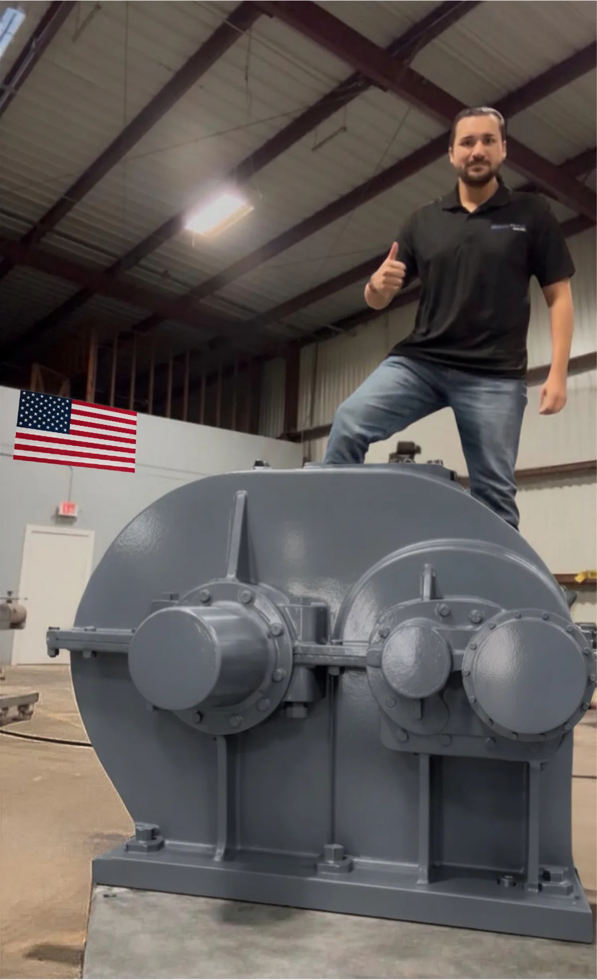 A Gear Force Machine team member standing on top of a large rebuilt industrial gearbox in the Rosharon, Texas shop, showing the scale of the units we service.