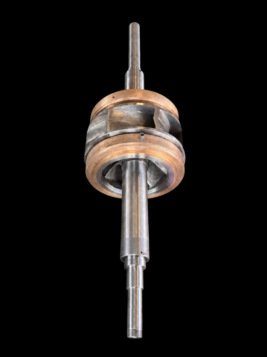 A rebuilt pump impeller and shaft assembly with bronze wear rings, removed from the casing.