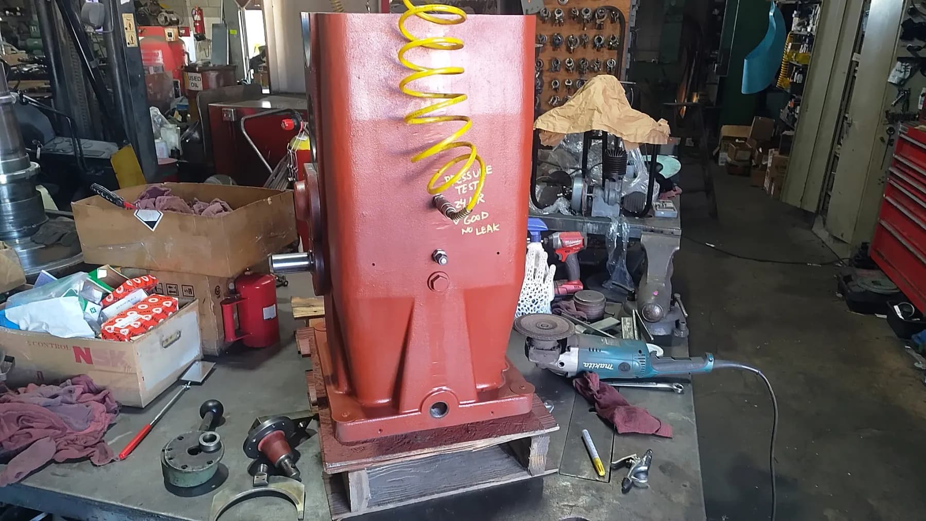 A rebuilt red gearbox tagged 'GOOD — NO LEAK' after pressure testing and final inspection.