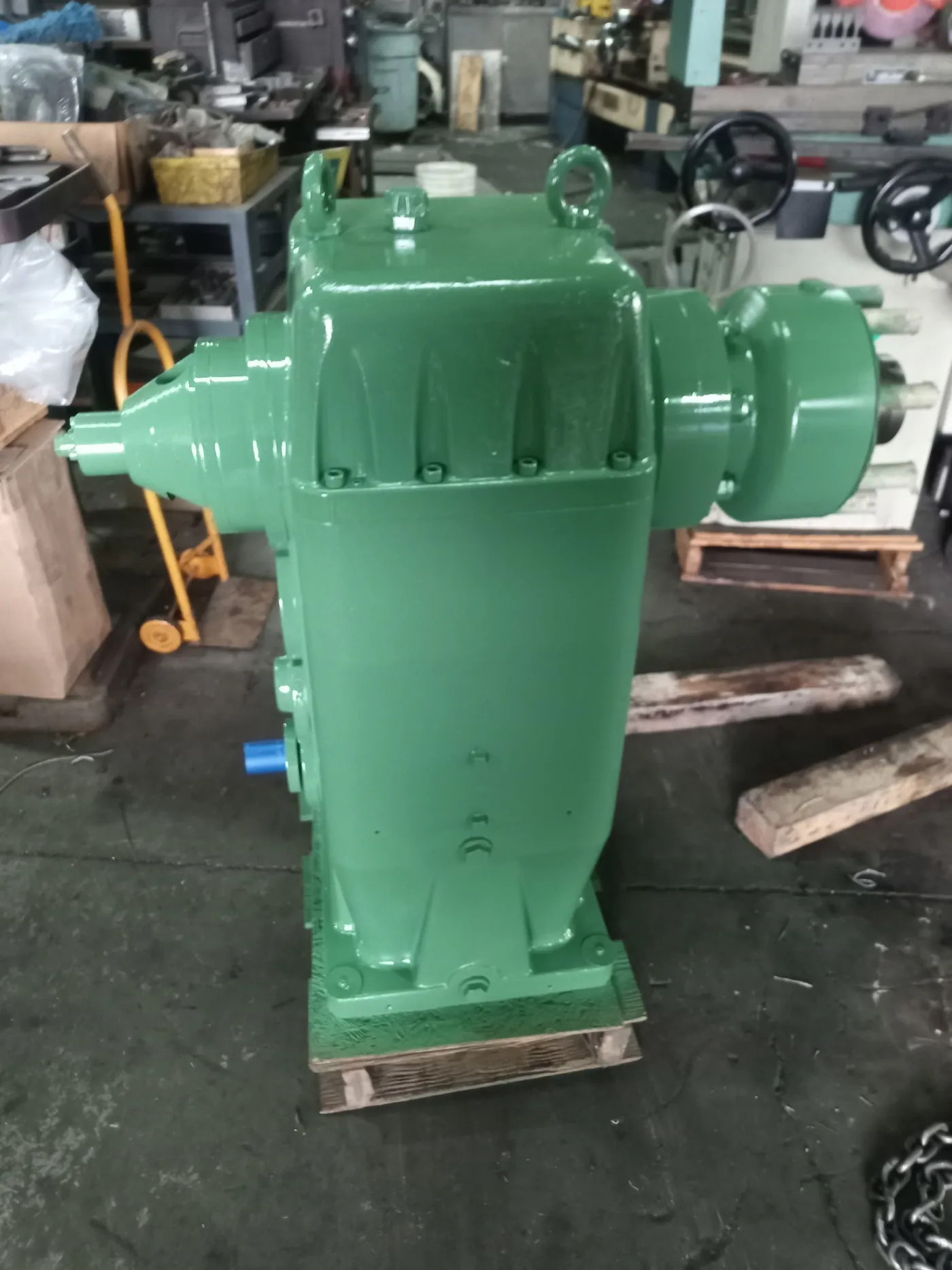 A red gearbox housing on the workbench during custom part fabrication.