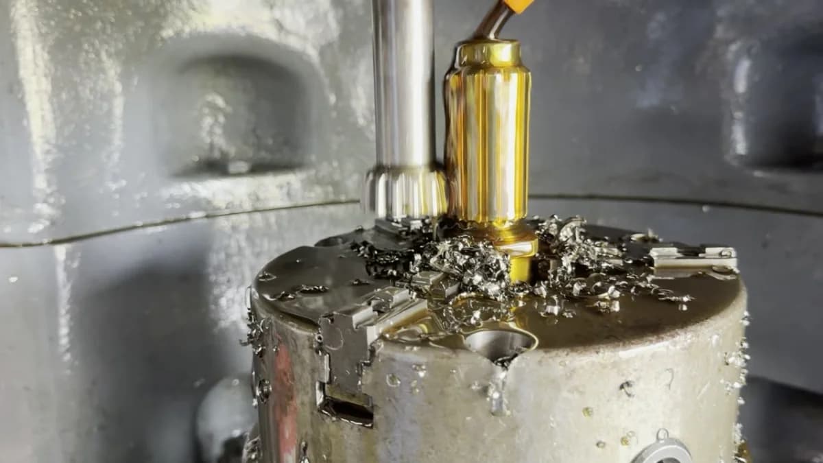 Close-up of a boring bar cutting into a large round steel workpiece, with cutting fluid and metal chips flying.
