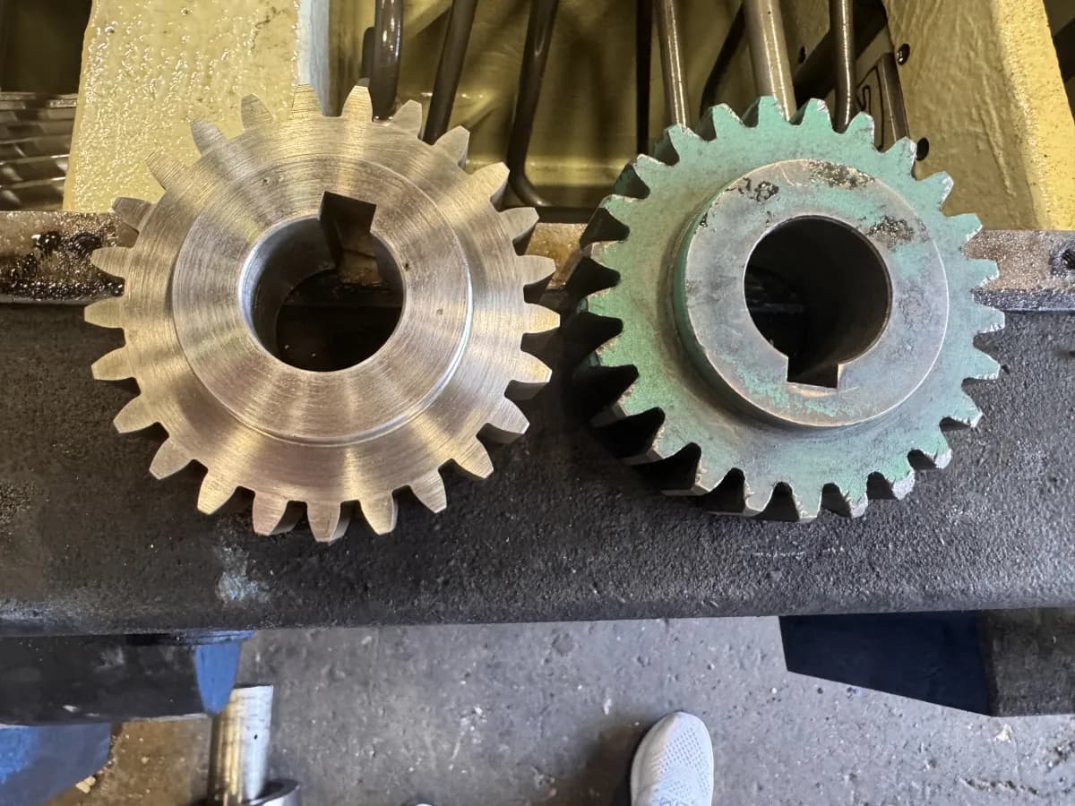 A matched pair of custom spur gears with machinist's layout dye, inspected for tooth contact before final fit.